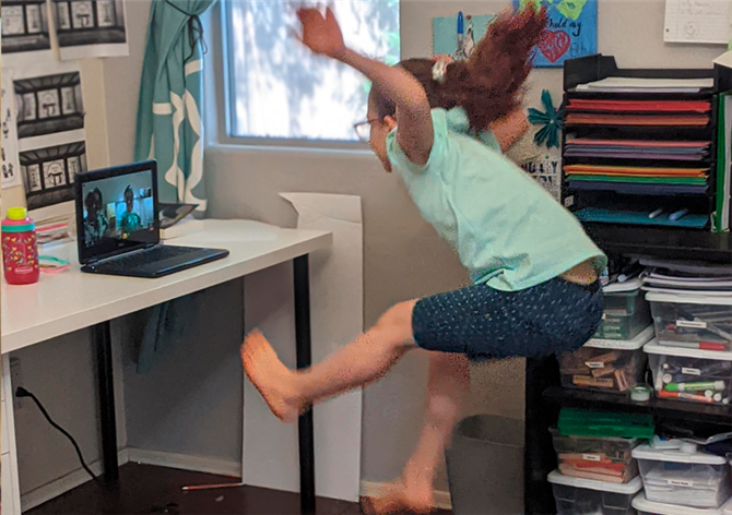 Excited girl is jumping during an online class