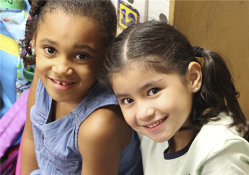 两个微笑的女孩在教室里＂width=