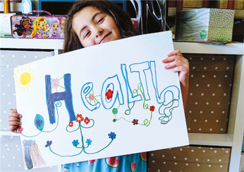 Girl holding a sign with the words HEALTH