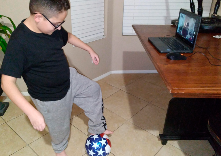 男孩在练习踢足球＂width=